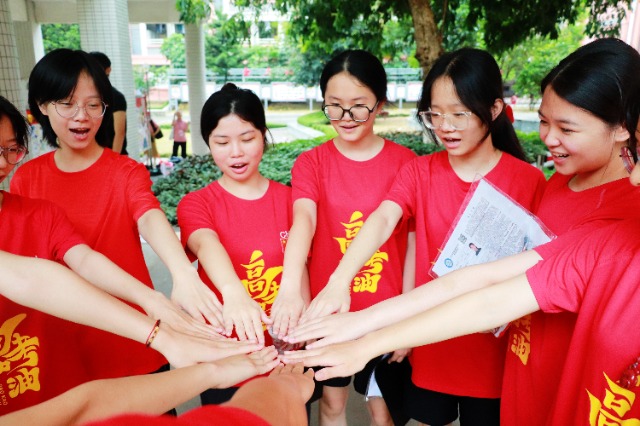 高考首日，玉林市第十中学的高三教师们列队为考生们加油鼓劲，现场氛围热烈。（图：侯杰 文：李泽瑞）.jpg