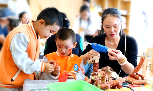 幼儿和家长用采摘的玉米进行民俗手工制作，为祖国妈妈献礼。宋雪莲摄.jpg