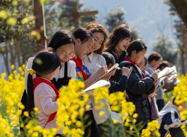 1、2026年3月12日，重庆市南川区金山镇小河坝社区油菜花田春意盎然，金山湖小学校的学生们在美术教师的指导进行写生，师生互动间传递着美育的温度。.jpg