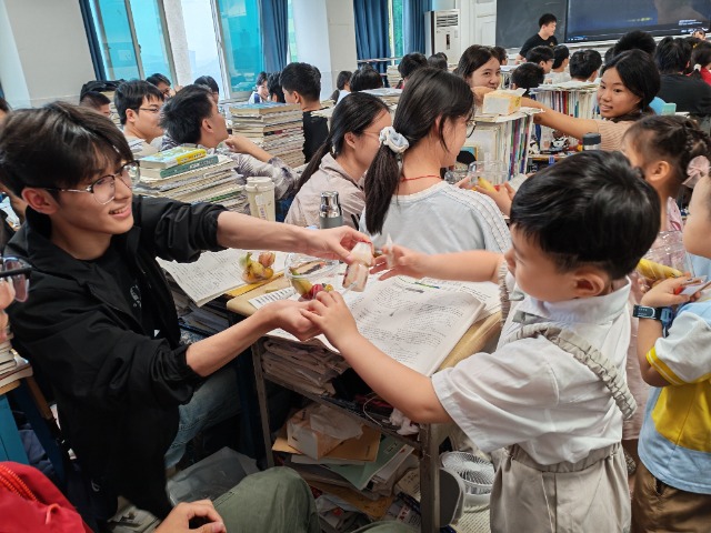 教室里高中生与小朋友们温馨互动传递食物,温情满满。忠县融媒体中心供图.jpg 教室里高中生与小朋友们温馨互动传递食物,温情满满。忠县融媒体中心供图.jpg