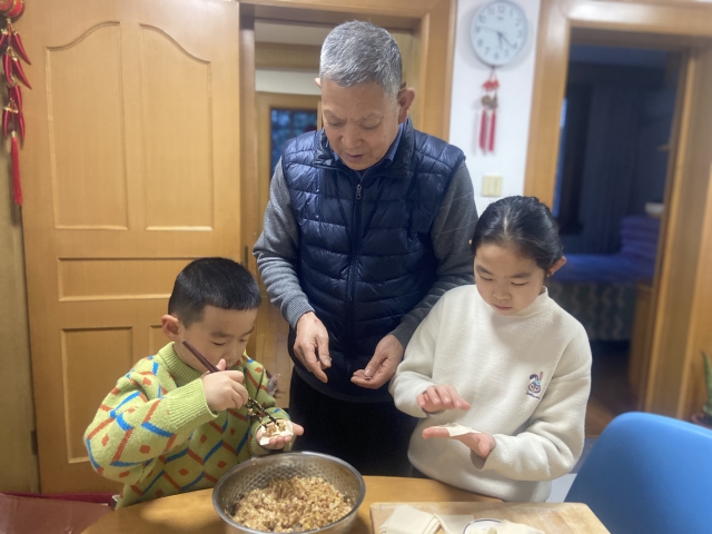 北仑区学生在家人的指导下包饺子 北仑区教育局供图.jpg