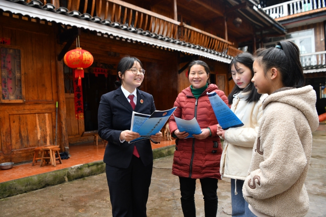 2022年2月18日，在贵州省黔东南苗族侗族自治州黄平县谷陇镇大寨村，一名检察院干警向家长和学生宣传《家庭教育促进法》。_proc.jpg