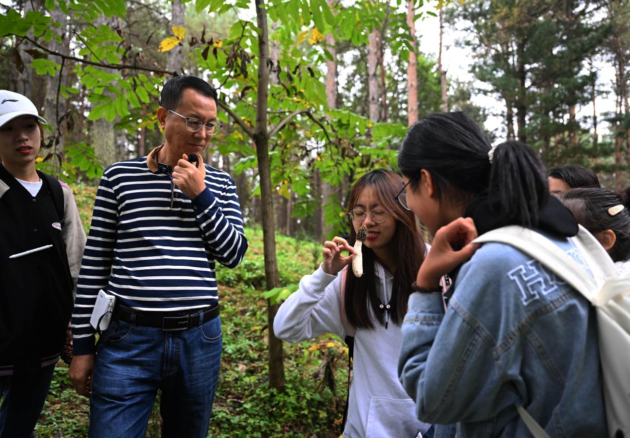 王占斌老师给同学们讲解辨识蘑菇。（学校供图）.jpg