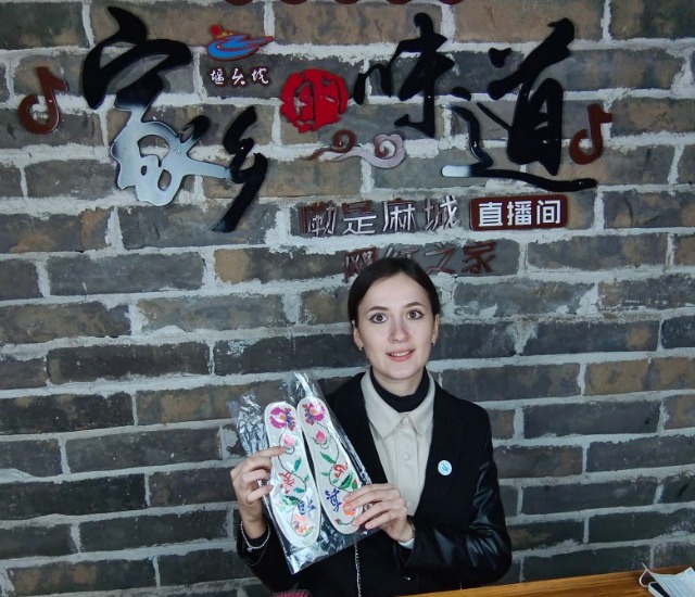 武汉轻工大学留学生在直播带货间展示绣花鞋垫.jpg