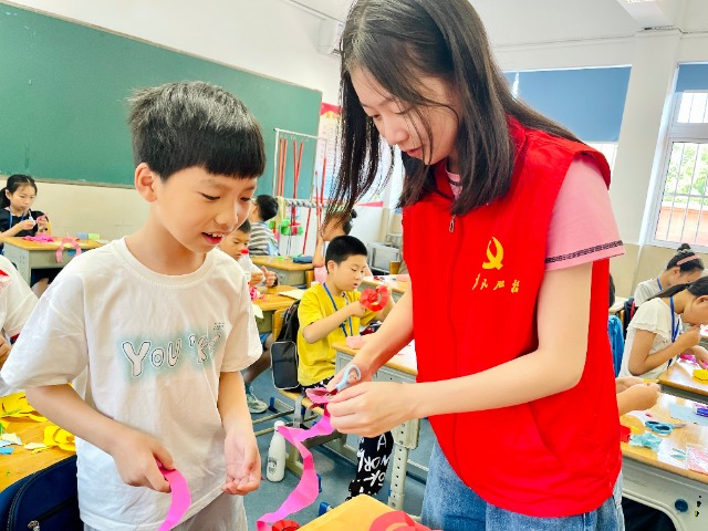 宁波财经学院暑期社会实践团成员在托管班指导学生做手工 周莹婷 摄.jpg