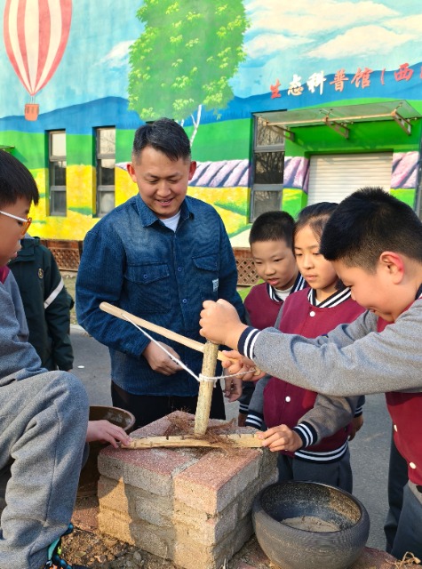 沈抚育才实验学校老师给学生们讲解钻木取火的科学原理.jpg