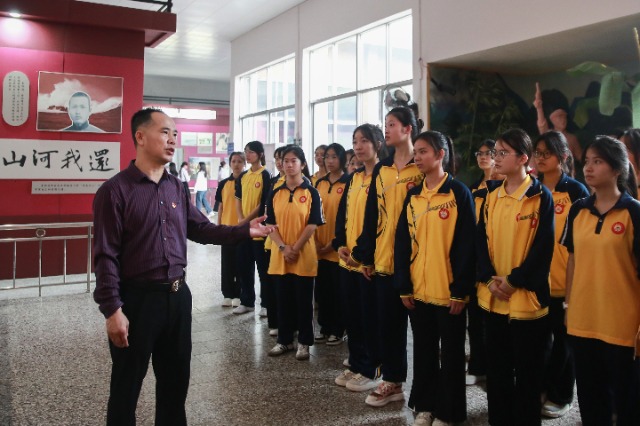 北流市明瑞高级中学党委副书记伍华生给学生讲述革命先烈的英勇事迹.jpg