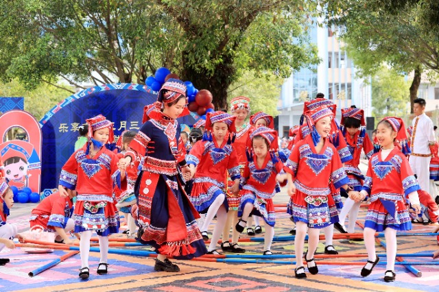 图4：4月9日，在广西柳州市融安县实验小学校园，一名老师带着学生跳竹竿舞。（谭凯兴 摄）.JPG