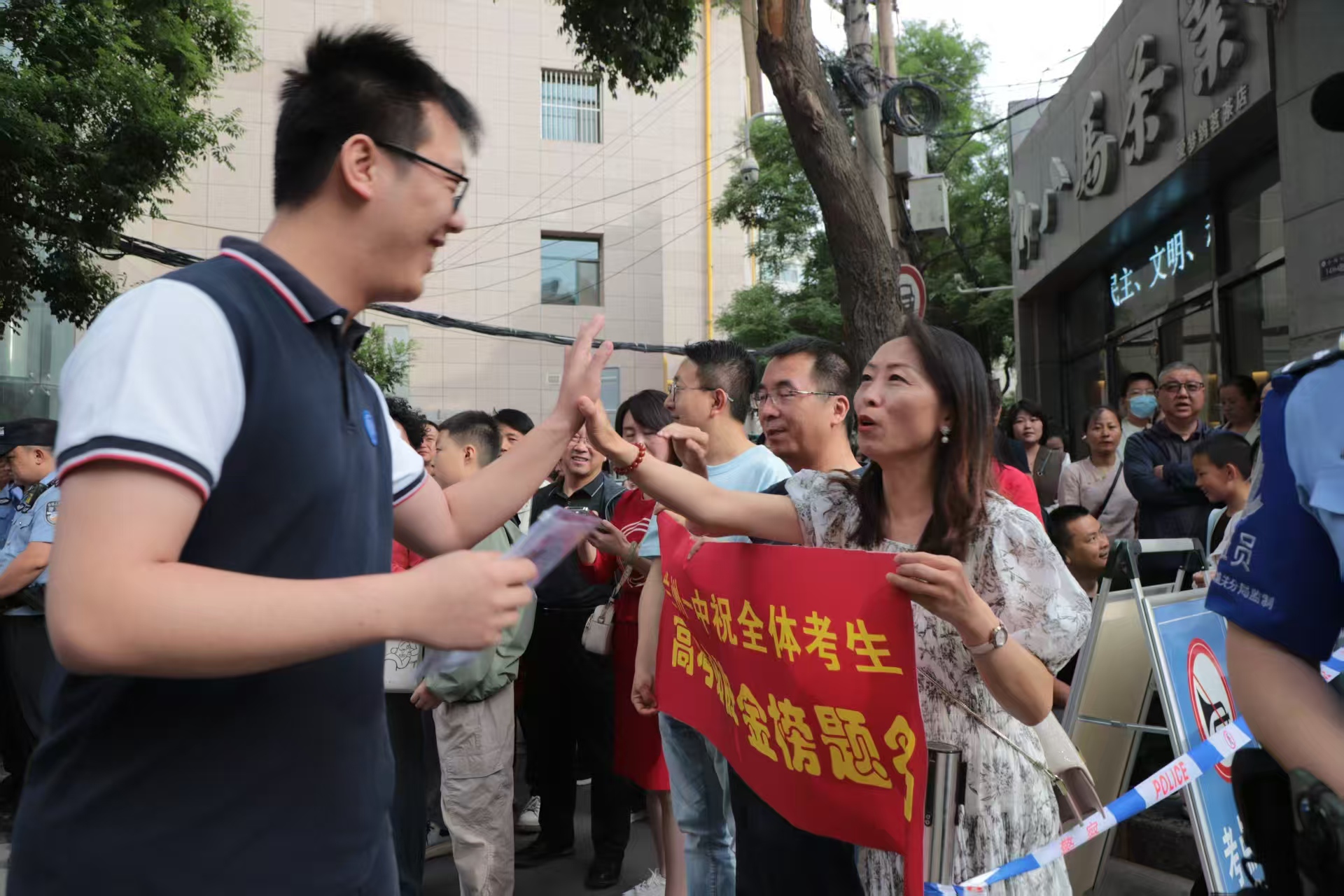 首场考试开考前，兰州一中教师在考场外暖心陪考送祝福，鼓励学生从容应对。（马绮徽 摄）.jpg