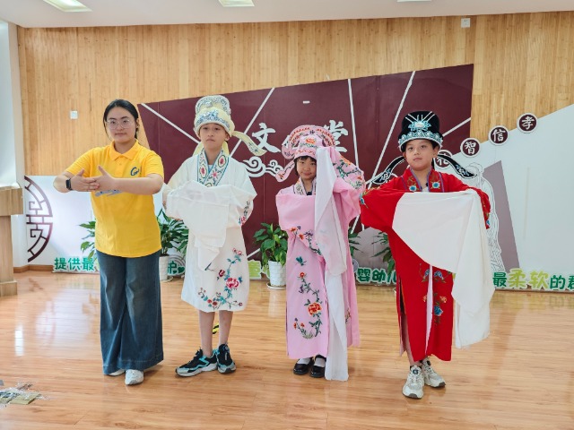 宁波职业技术大学“拾梦非遗”服务队教小朋友们学唱传统戏曲 学校供图.jpg