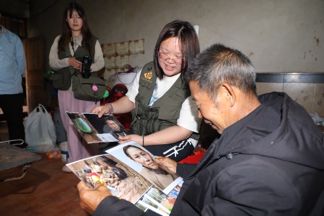 队员为兰学民送来照片，并借助AIGC技术为兰学民修复老伴的证件照。周洲 摄.JPG